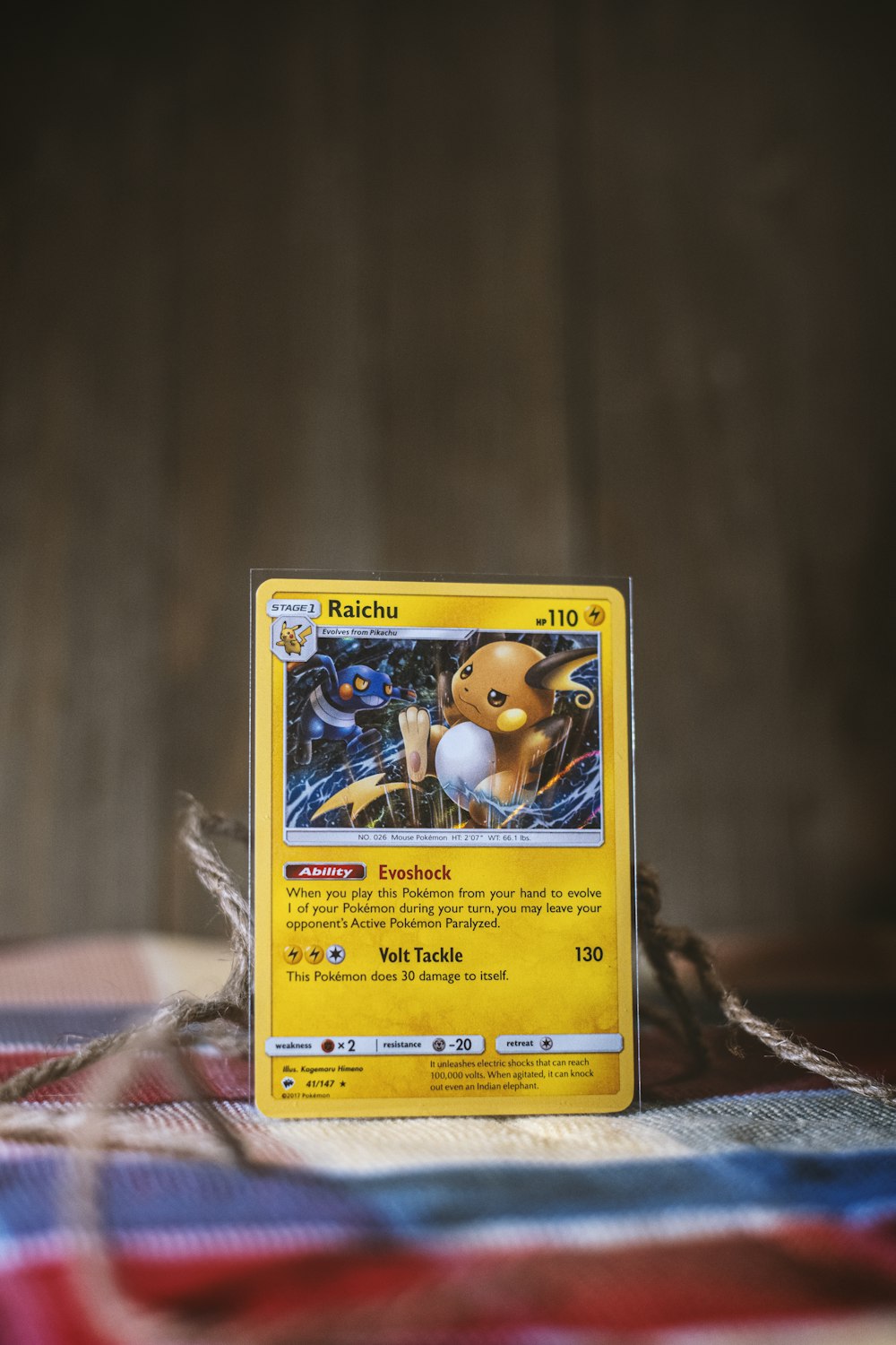 A single Pokemon card standing upright, lit against a dark background