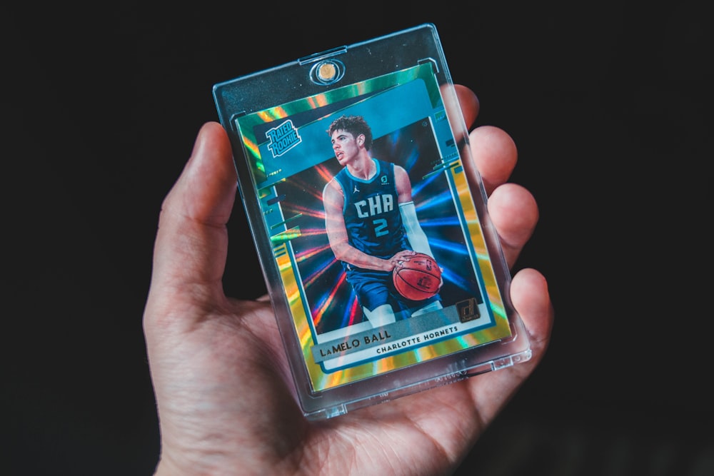 A graded card in a magnetic holder held up against a dark background