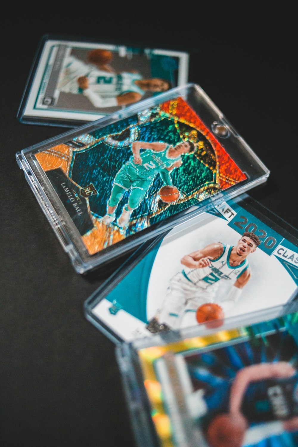 Several graded card slabs laid out on a dark table